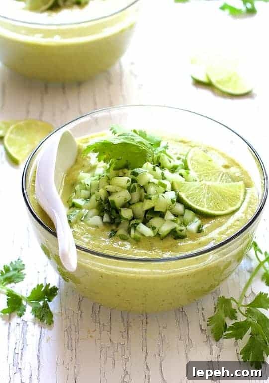 Cold Thai Cucumber Avocado Soup with Cucumber Relish in glass bowl.