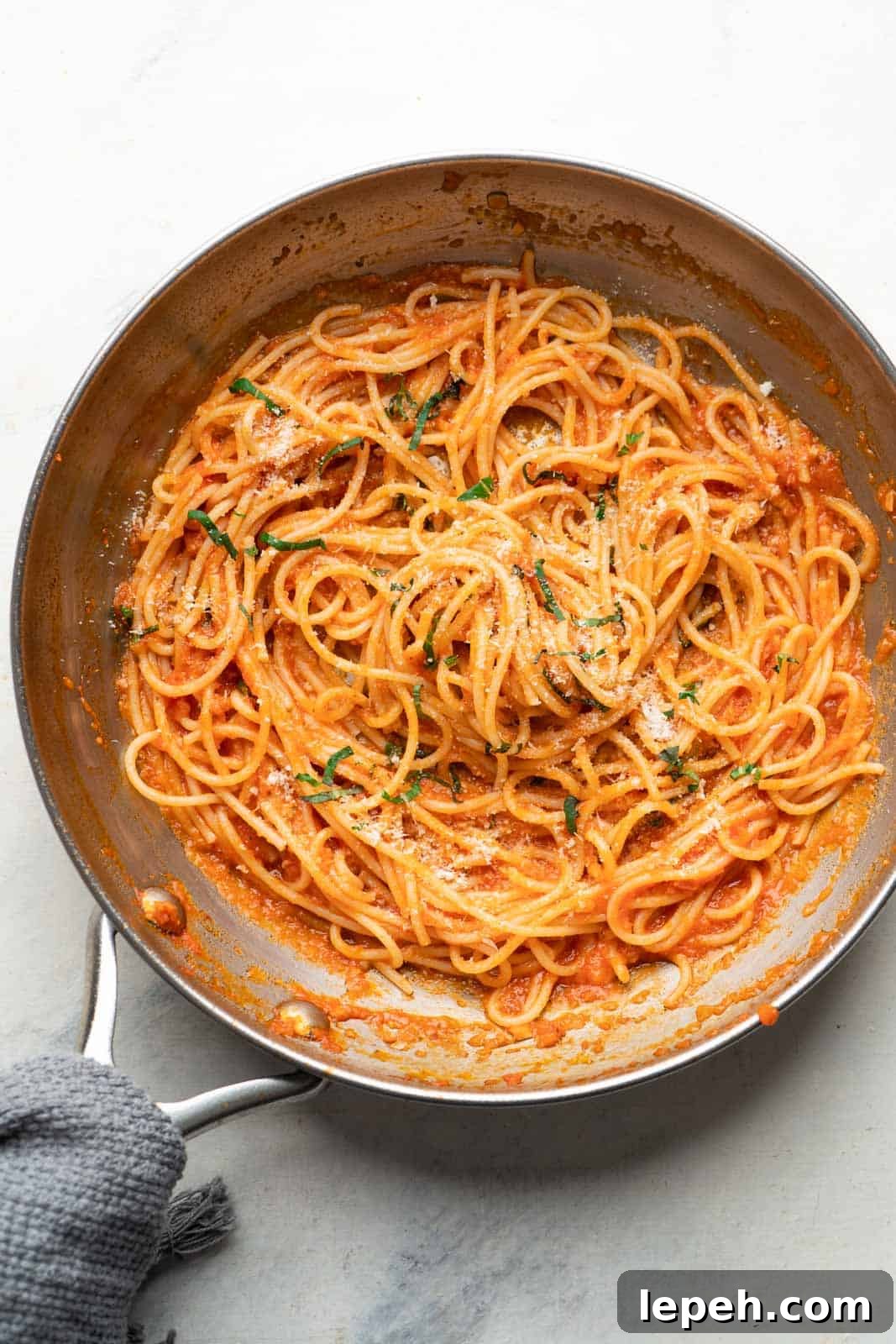 Spaghetti tossed in pasta sauce in a skillet