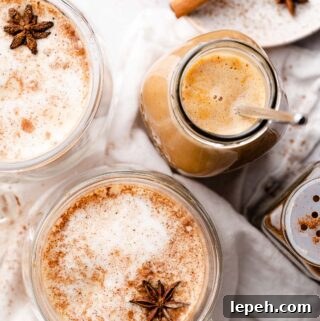 pumpkin spice syrup in glass jar with lattes on the side