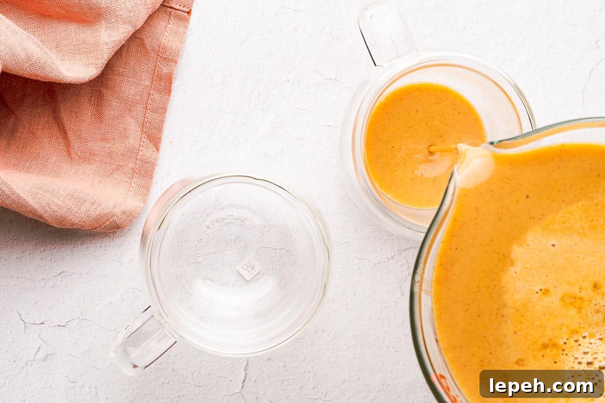 pumpkin spice syrup being poured into glass mug