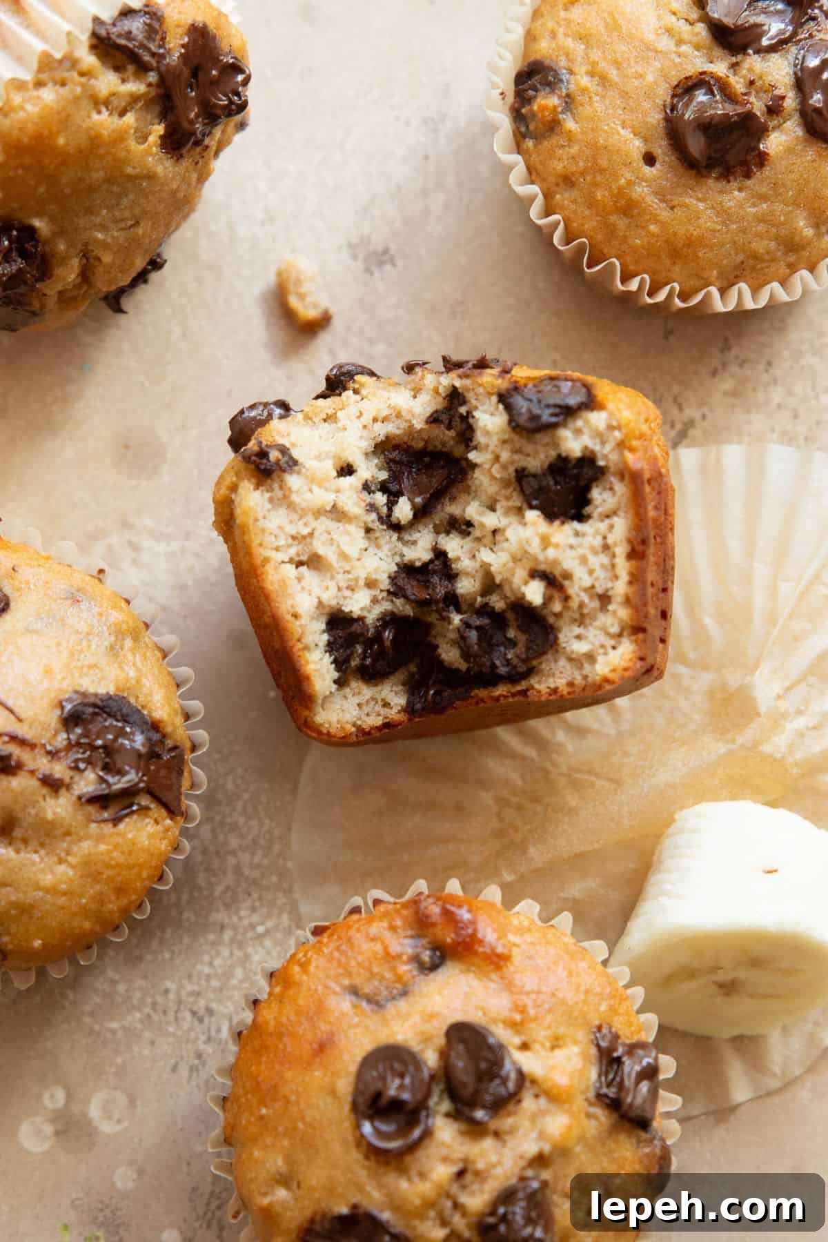 Healthy chocolate chip banana protein muffins with bite taken out to show the fluffy, moist interior.