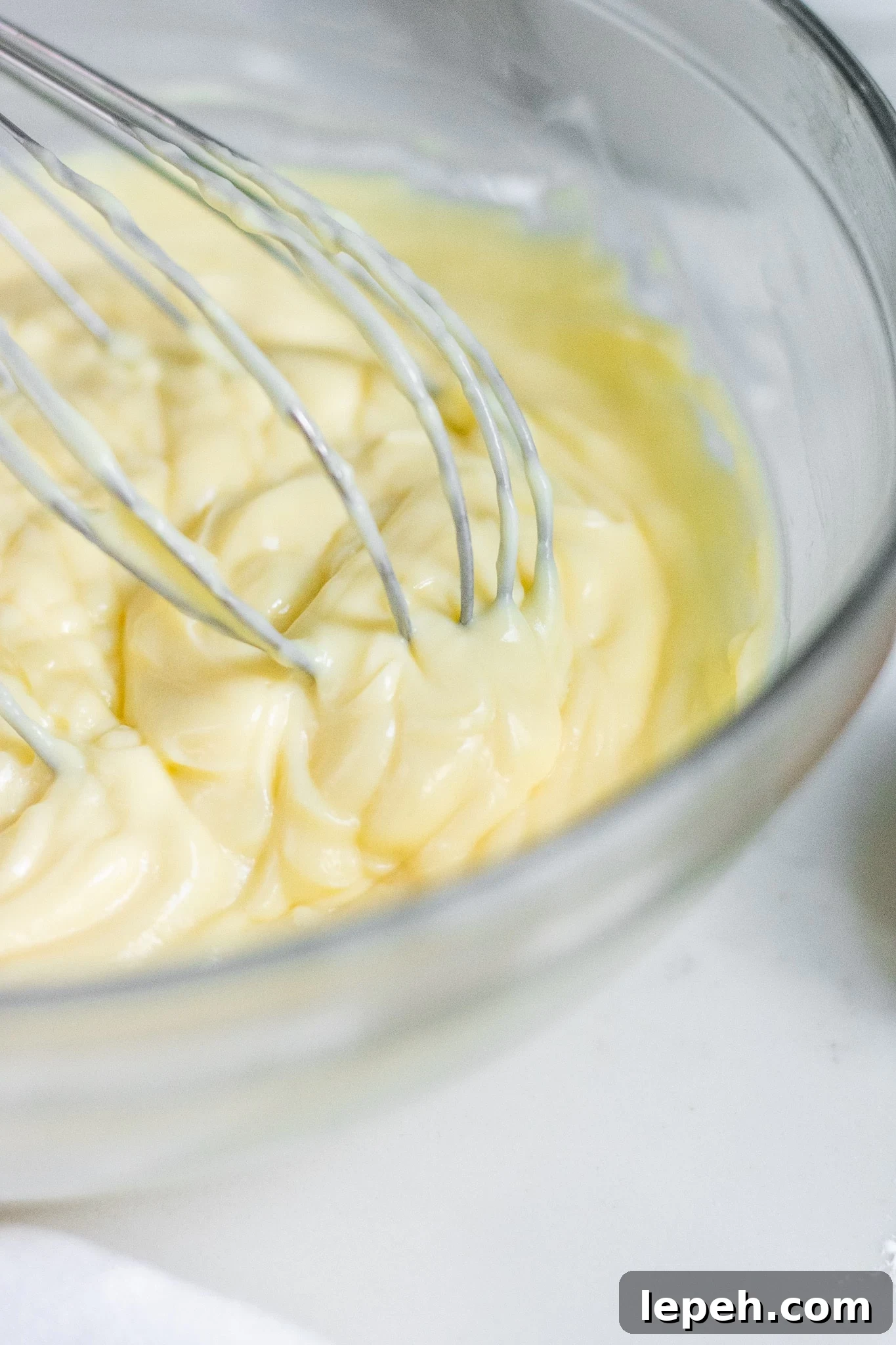 Pastry cream in a bowl with a whisk.
