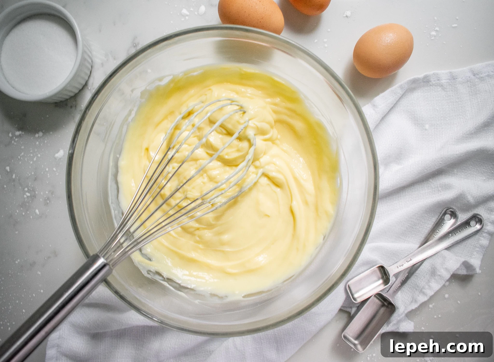 Pastry cream in a bowl with a whisk.