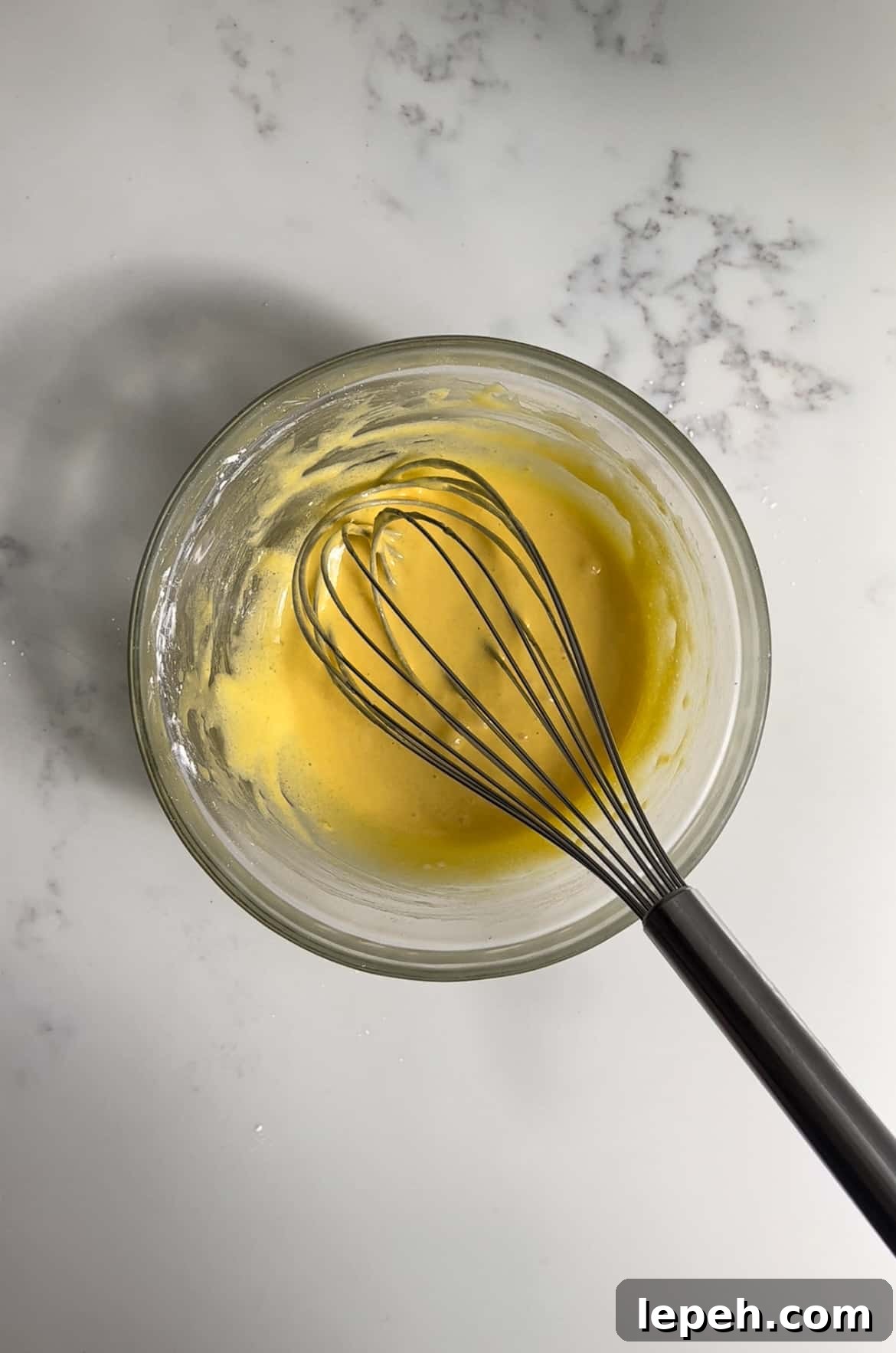 Ingredients for pastry cream whisked together in a bowl.