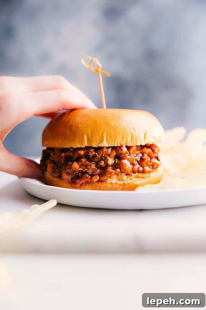 Turkey sloppy joes on a plate, held by a hand, ready to be savored.