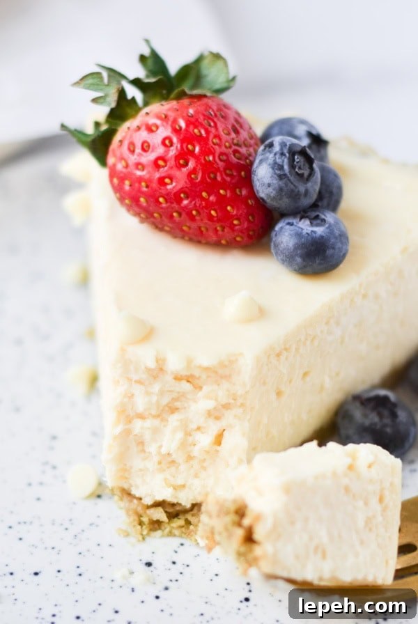 A white chocolate cheesecake slice with berries on top.