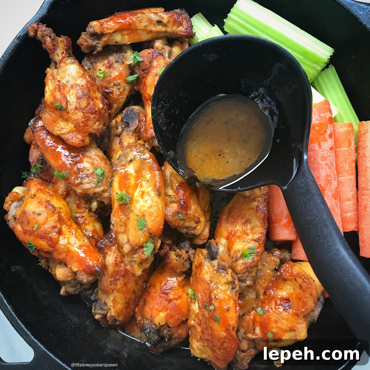 overhead shot of cooked Buffalo chicken wings garnished with celery & carrots