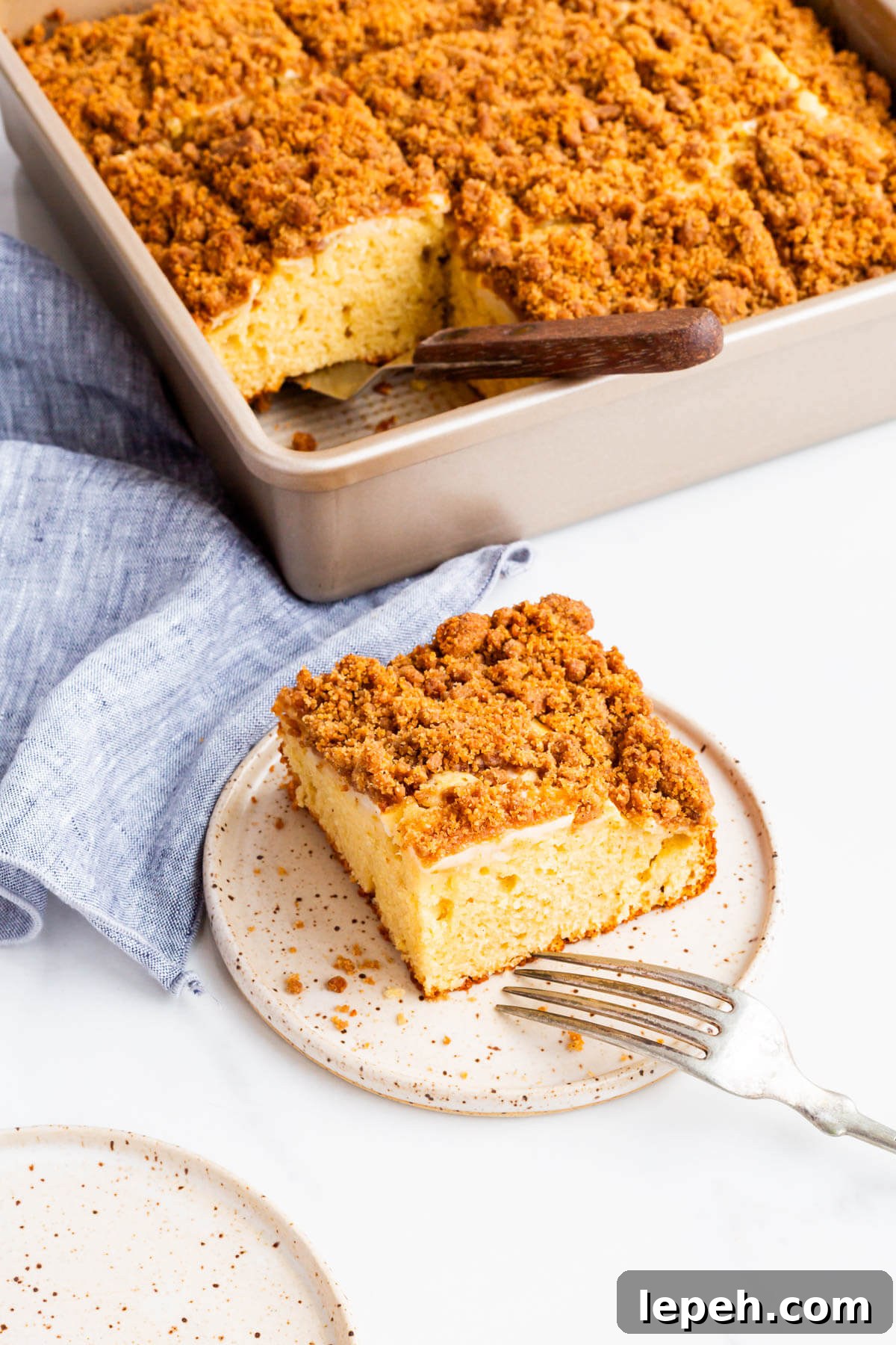 Apple coffee cake served on a dessert plate with a fork.