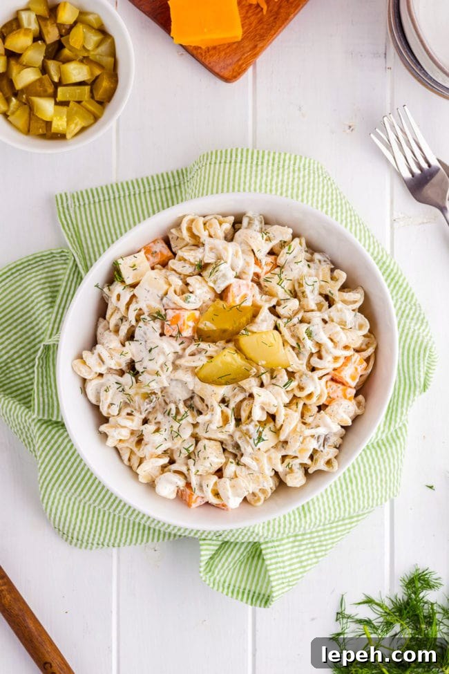 Dill pickle pasta salad in a white bowl with a green towel