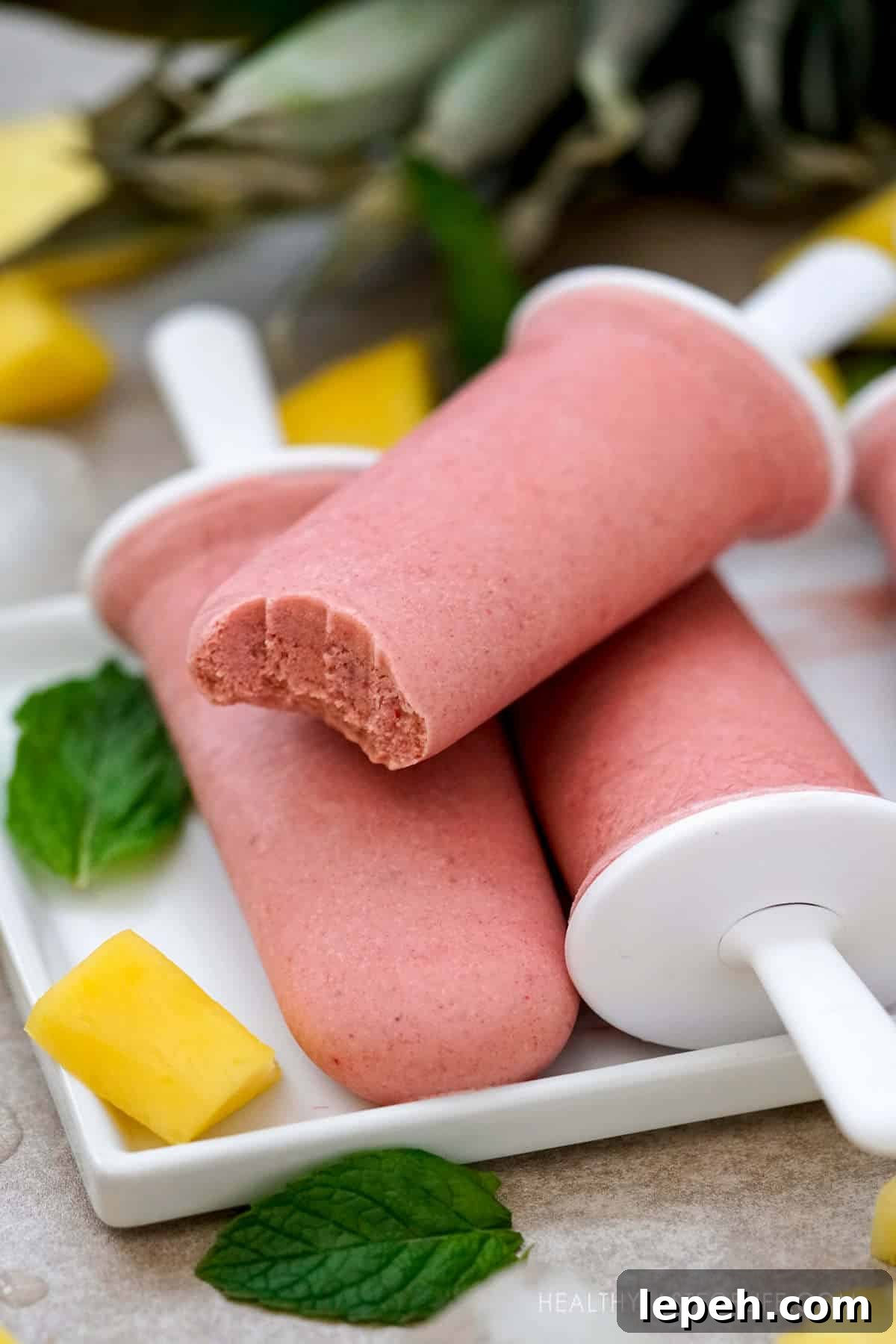 Healthy tropical popsicles made with mango, pineapple, banana and strawberry.