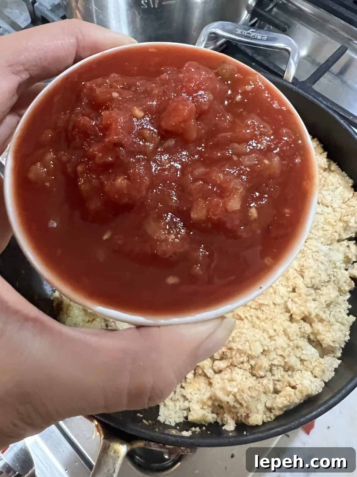 process of adding salsa to cauliflower rice