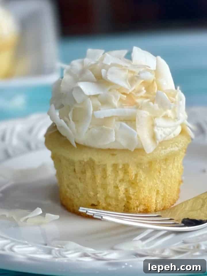 A plate with a Coconut Cream Cupcake with Whipped Cream Frosting