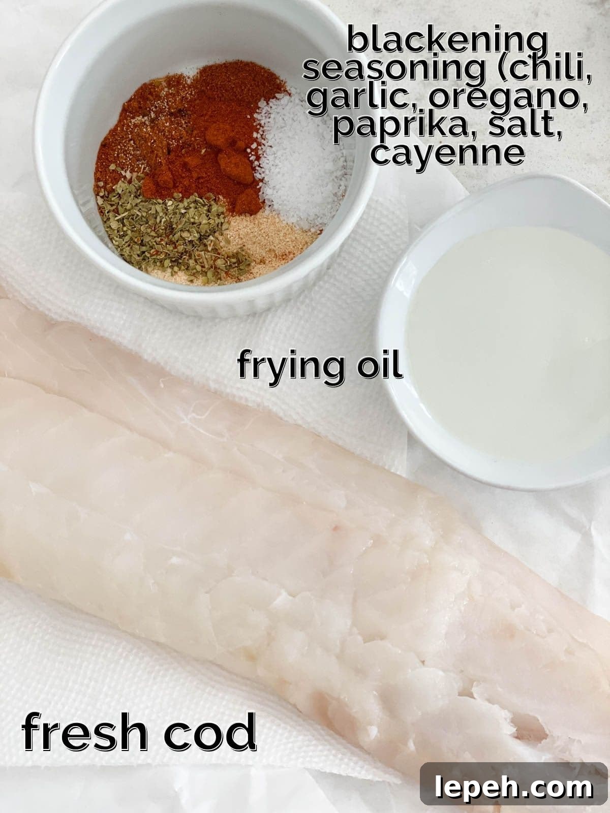 Spices, cod, and oil on a white table