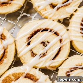 cinnamon roll cookies with icing on cooling rack