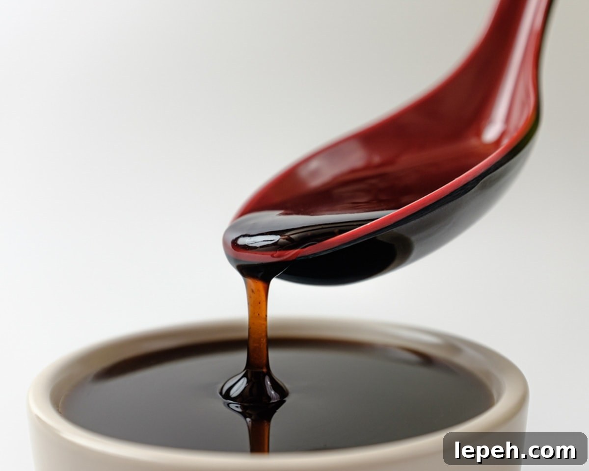Spoon pouring teriyaki sauce into a bowl.