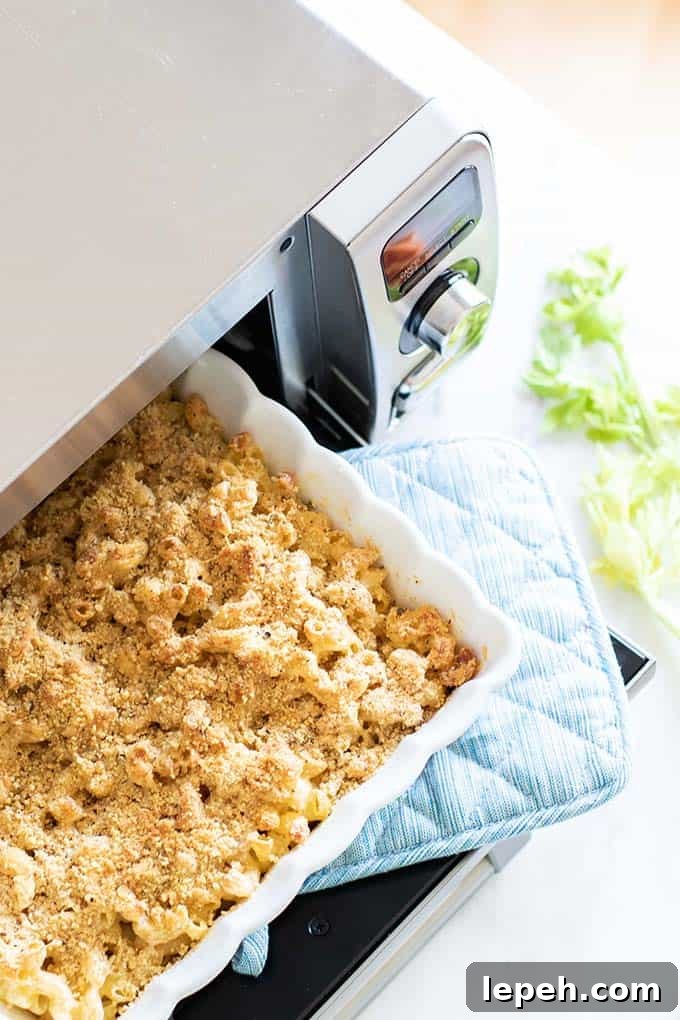 A pan of freshly baked buffalo chicken mac and cheese coming out of the oven.