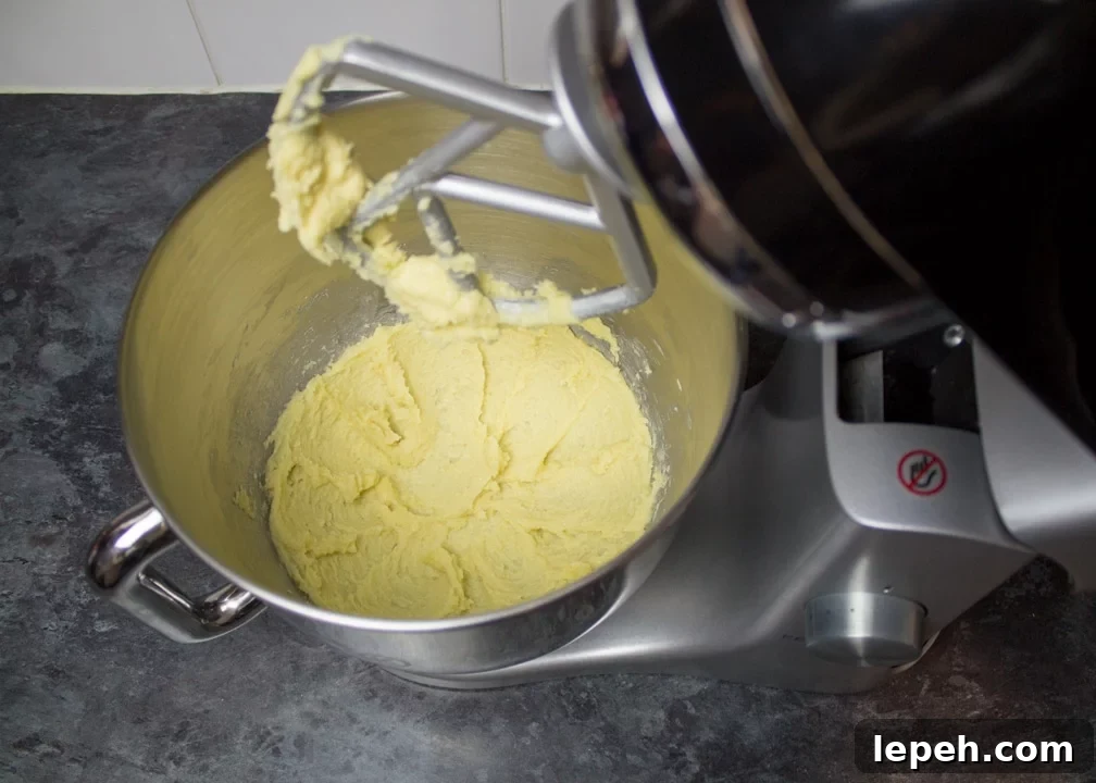 Creamed butter and sugar in an electric stand mixer on a kitchen worktop.