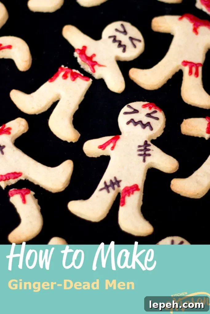 Flat lay view of lots of decorated ginger-dead men Halloween biscuits against a black background.