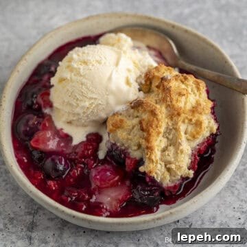 Triple Berry Cobbler topped with a scoop of ice cream.