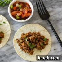 taco meat on tortillas with salsa on the side