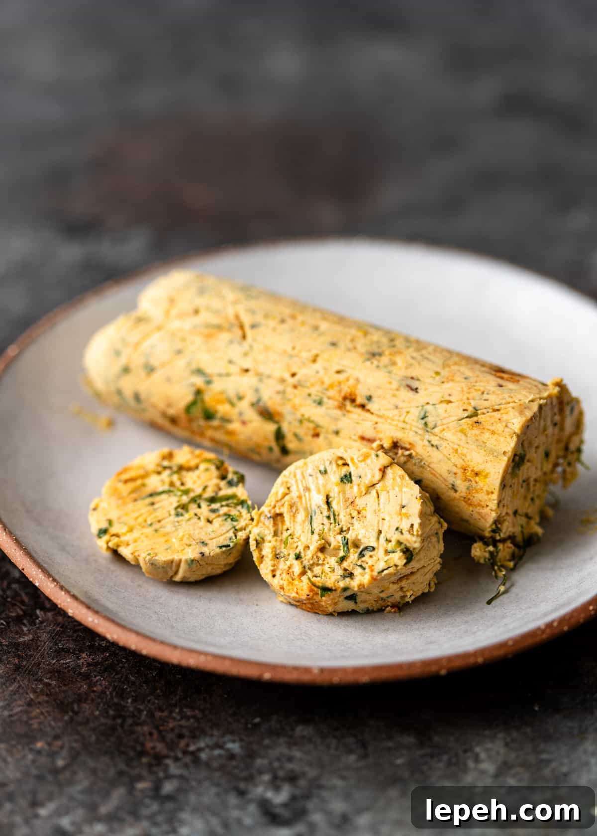 closeup: a log of cowboy butter with two slices cut off 