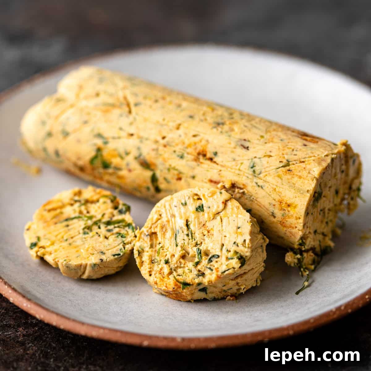 closeup: my cowboy butter recipe shaped into a log on a plate