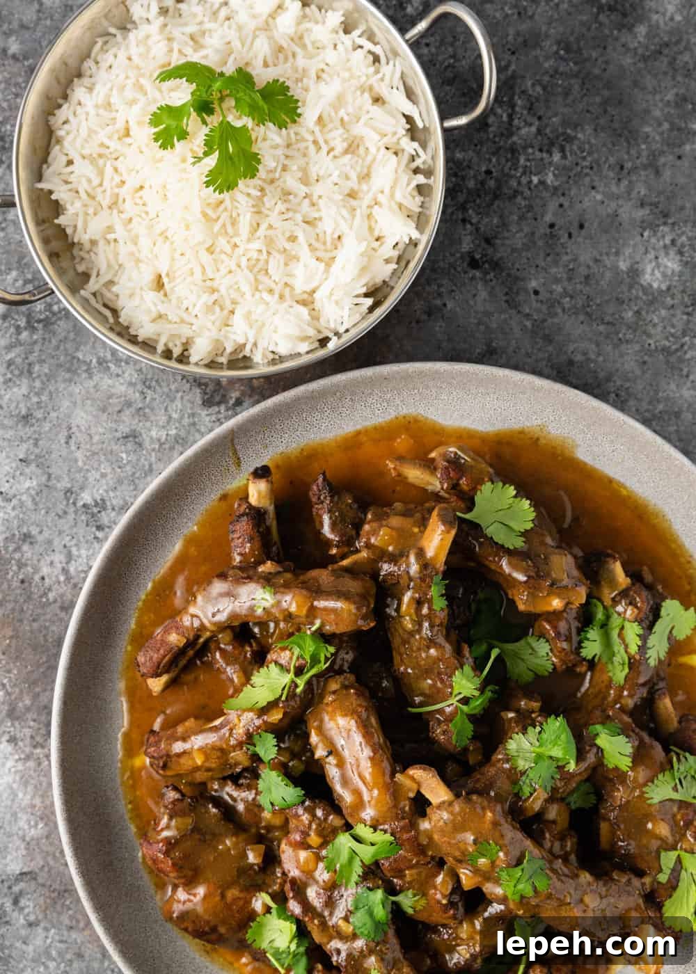 overhead photo: plated Instant pot asian ribs with brown sauce next to dish of white rice