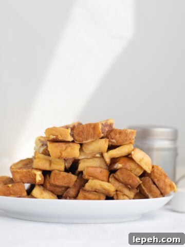 a pile of french toast sticks on a white plate