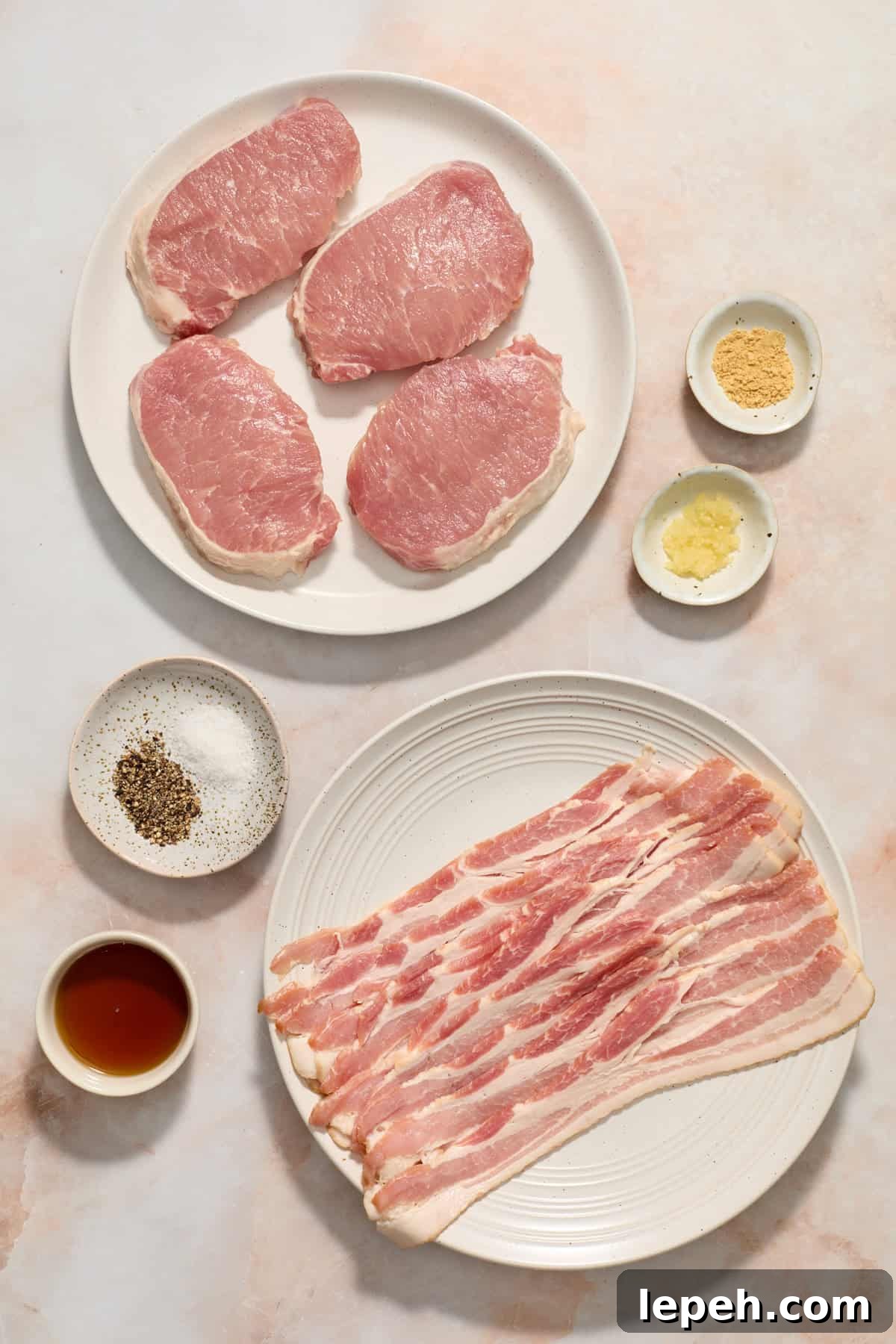 Pork chops, bacon, syrup and other ingredients arranged on surface.
