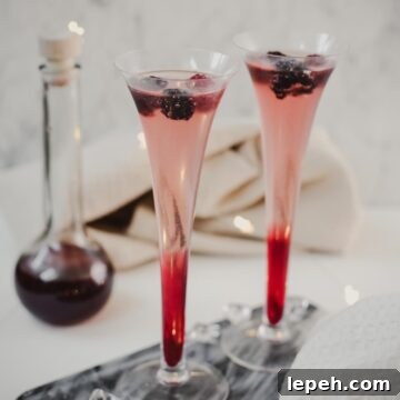 Chambord and Champagne Cocktail Recipe: Elegant Raspberry Sparkler 5 Champagne and chambord cocktail served in two champagne flutes. Garnished with berries.